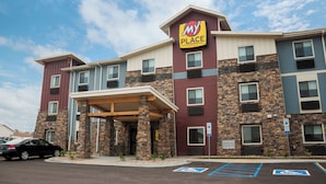 A multi-story hotel with a 'My Place' sign, a covered entrance, and handicap-accessible parking.