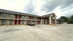 A motel with a two-story structure, multiple rooms, and a parking lot.