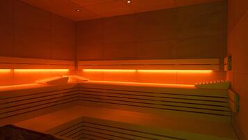 A modern spa room with a bench and a massage table.