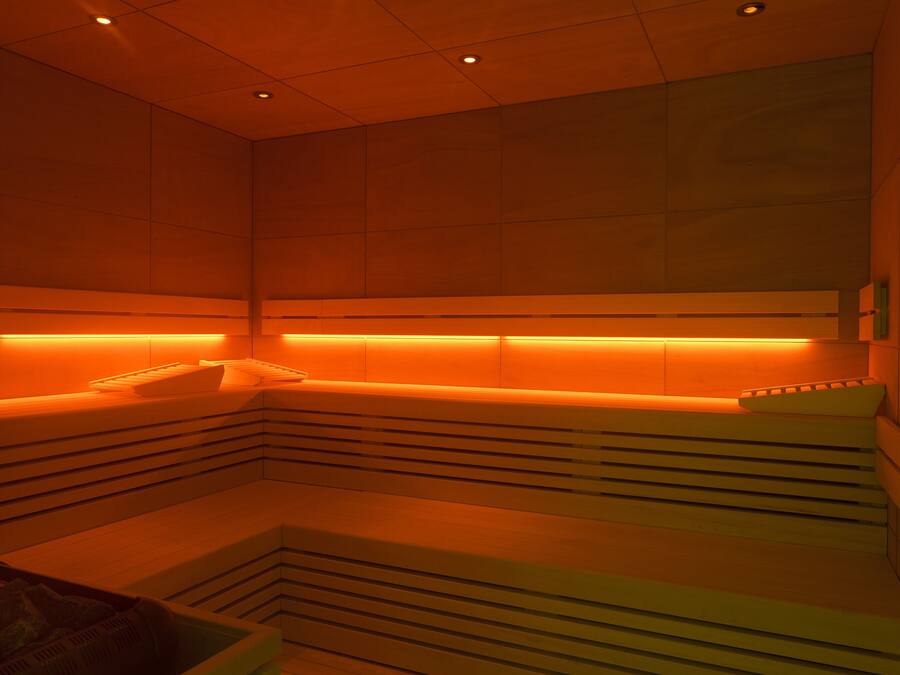 A modern spa room with a bench and a massage table.
