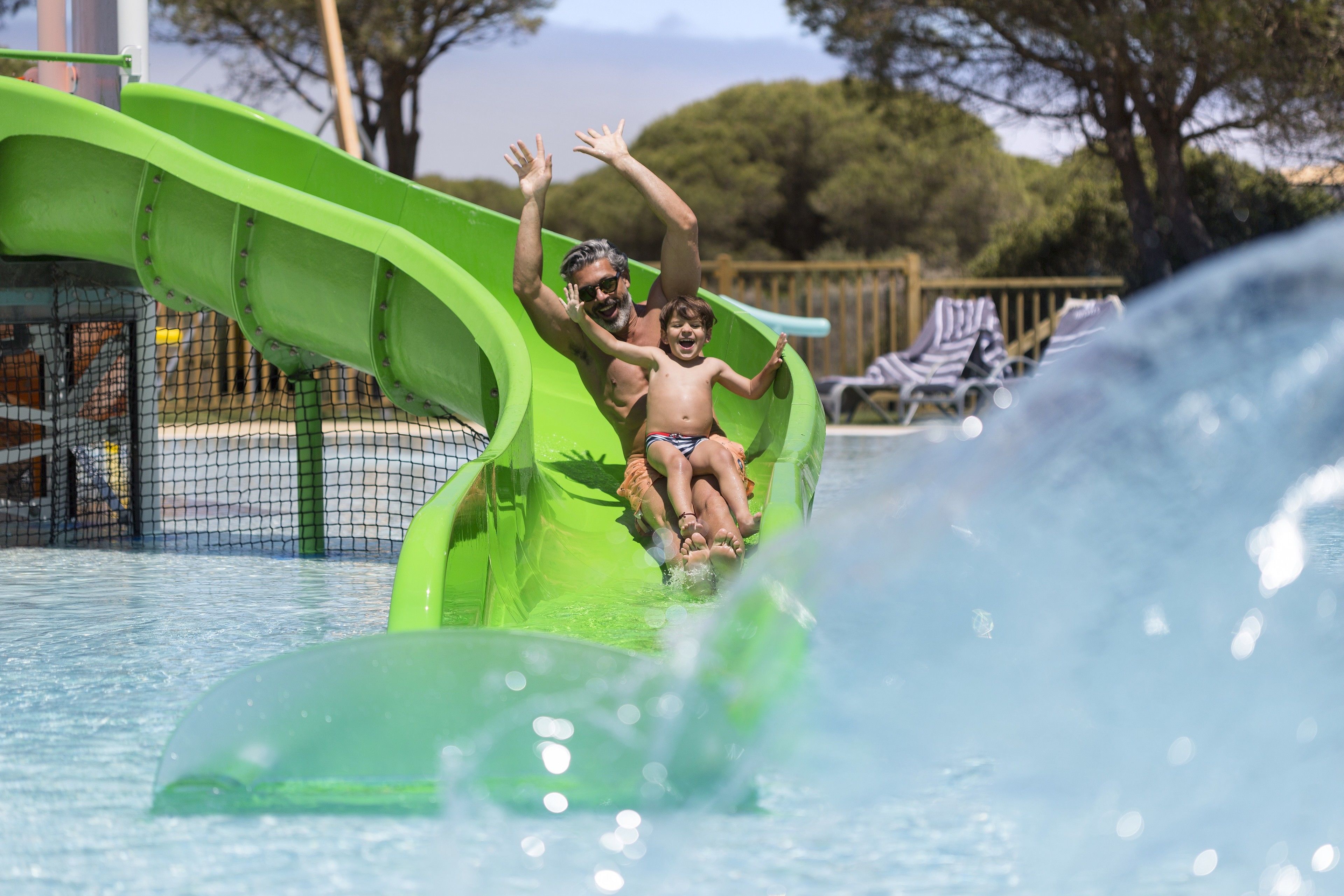 A water slide at a water park with a pool in the foreground.
