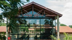 A modern building with a glass facade and a metal roof structure. - Village Cataratas (Puerto Iguazú)