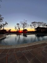 Een buitenzwembad, parasols voor strand/zwembad