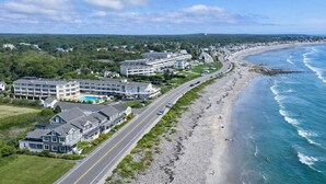 A coastal hotel with multiple buildings, a road adjacent to the beach, and ocean views. -  Ocean Sands at York Beach (York Beach)