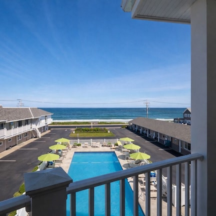 A motel with a pool, outdoor seating, and ocean views.