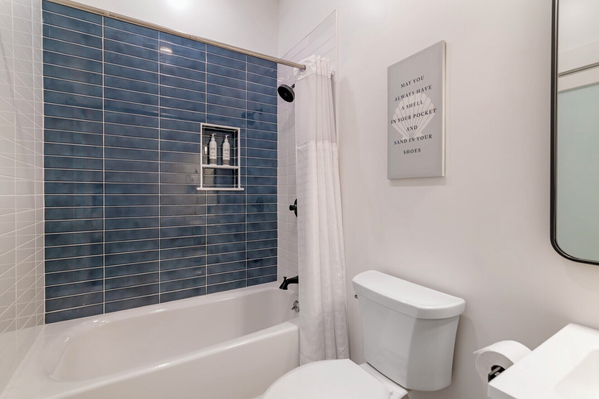 A bathroom with a bathtub, toilet, and a shower curtain.