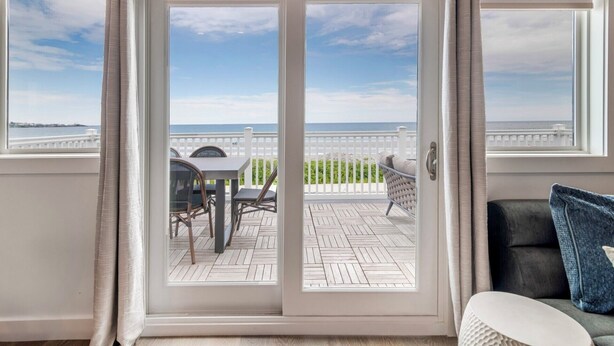 A room with a sliding glass door leading to a balcony with a view of the sea. -  Ocean Sands at York Beach (York Beach)