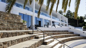 A modern building with a stone facade, multiple balconies, and a staircase leading to the entrance. - Ellia Hotel (Rhodes)
