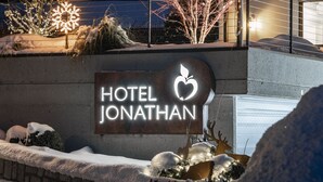 A hotel sign with a leaf logo, surrounded by snow and winter decorations. - Hotel Jonathan (Naz Sciaves)