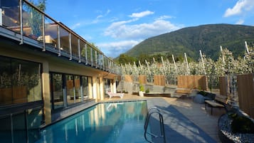 Piscine couverte, piscine extérieure, parasols de plage, chaises longues