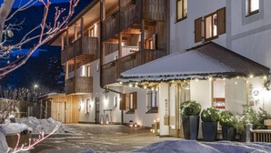 A hotel with a wooden facade, multiple balconies, and a snow-covered entrance. - Hotel Jonathan (Naz Sciaves)