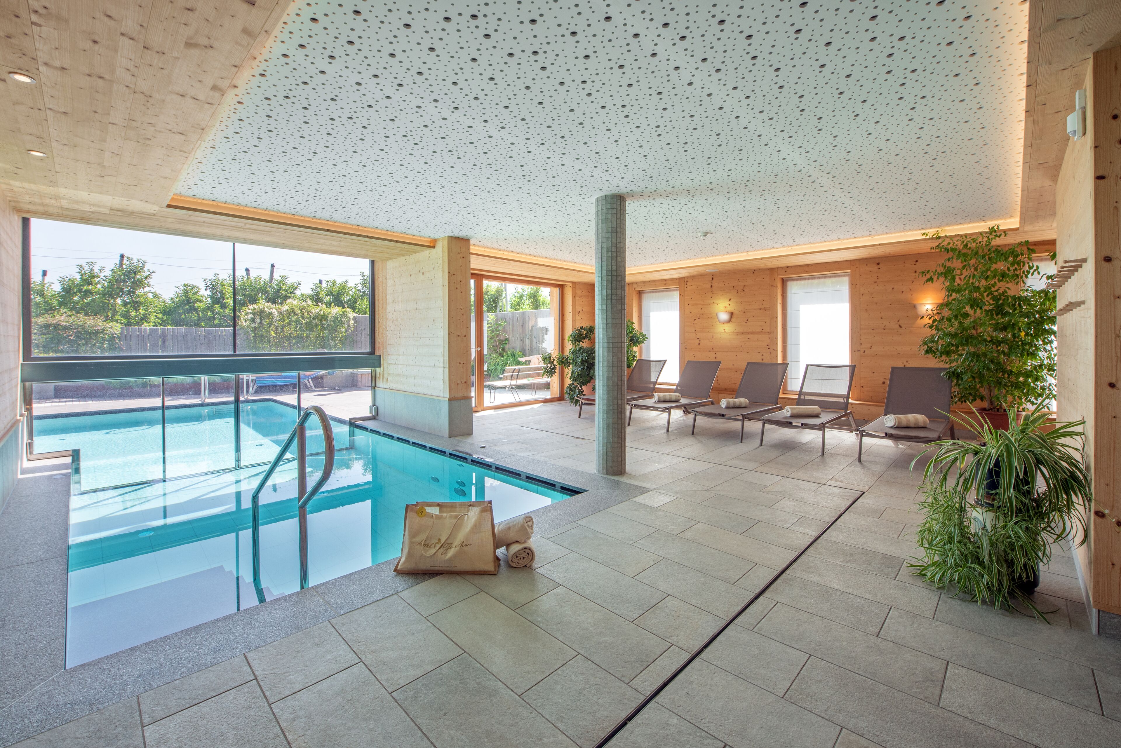 Een binnenzwembad, een buitenzwembad, parasols voor strand/zwembad