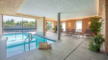 Een binnenzwembad, een buitenzwembad, parasols voor strand/zwembad