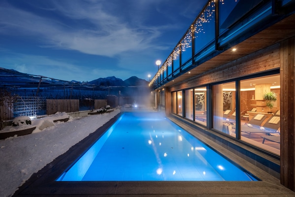 Een binnenzwembad, een buitenzwembad en parasols bij het zwembad