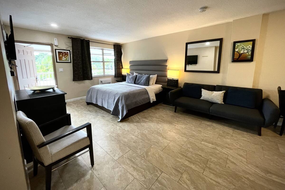 Een hotelkamer met een bed, een slaapbank, een bureau en een stoel.