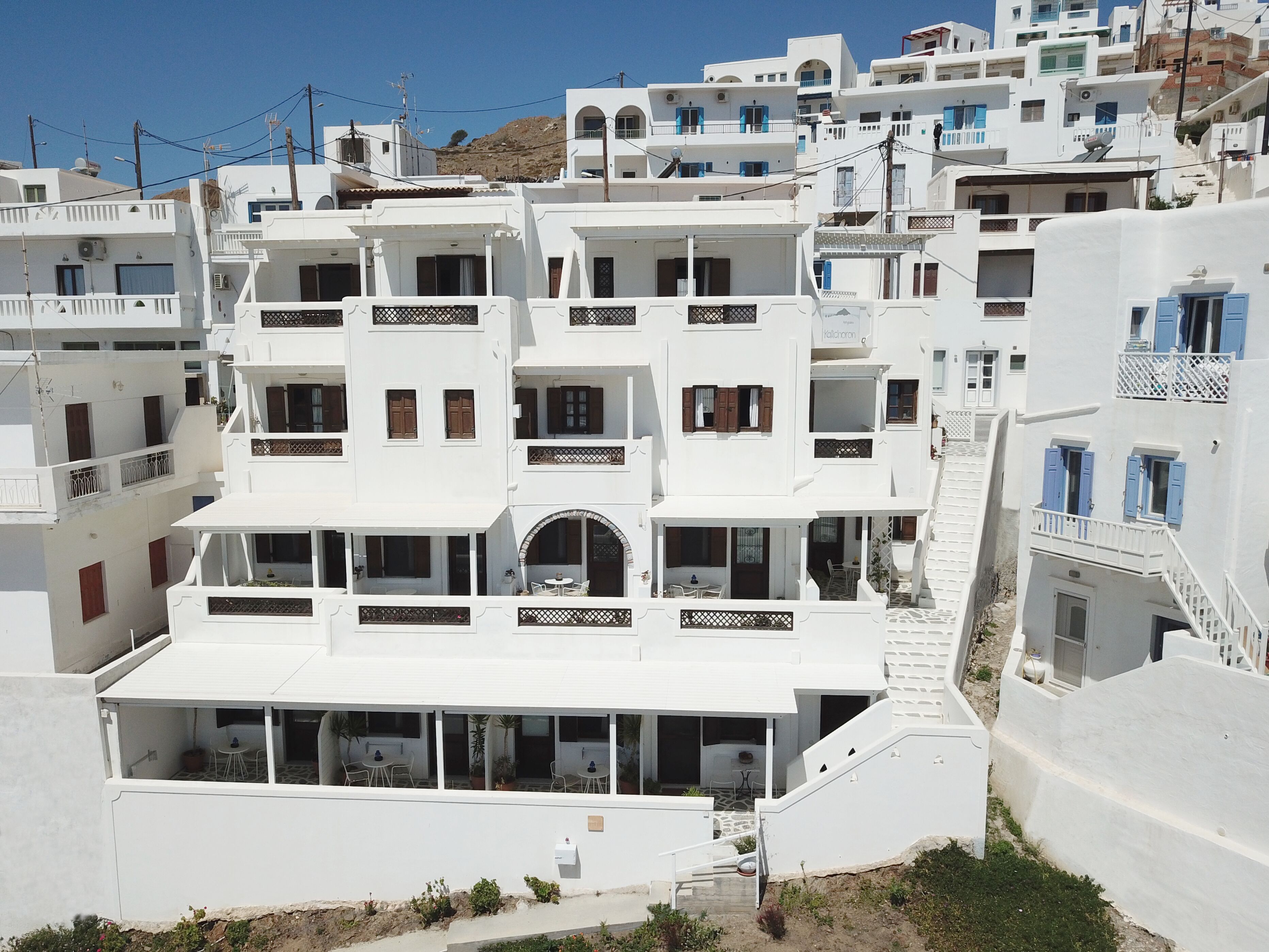 Un edificio blanco con varios balcones y una escalera que conduce a los pisos superiores.