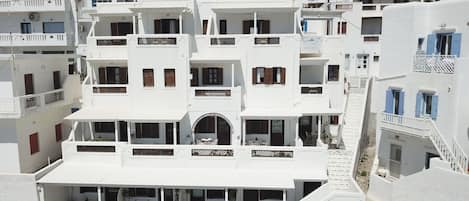 Un edificio blanco con varios balcones y una escalera que conduce a los pisos superiores.