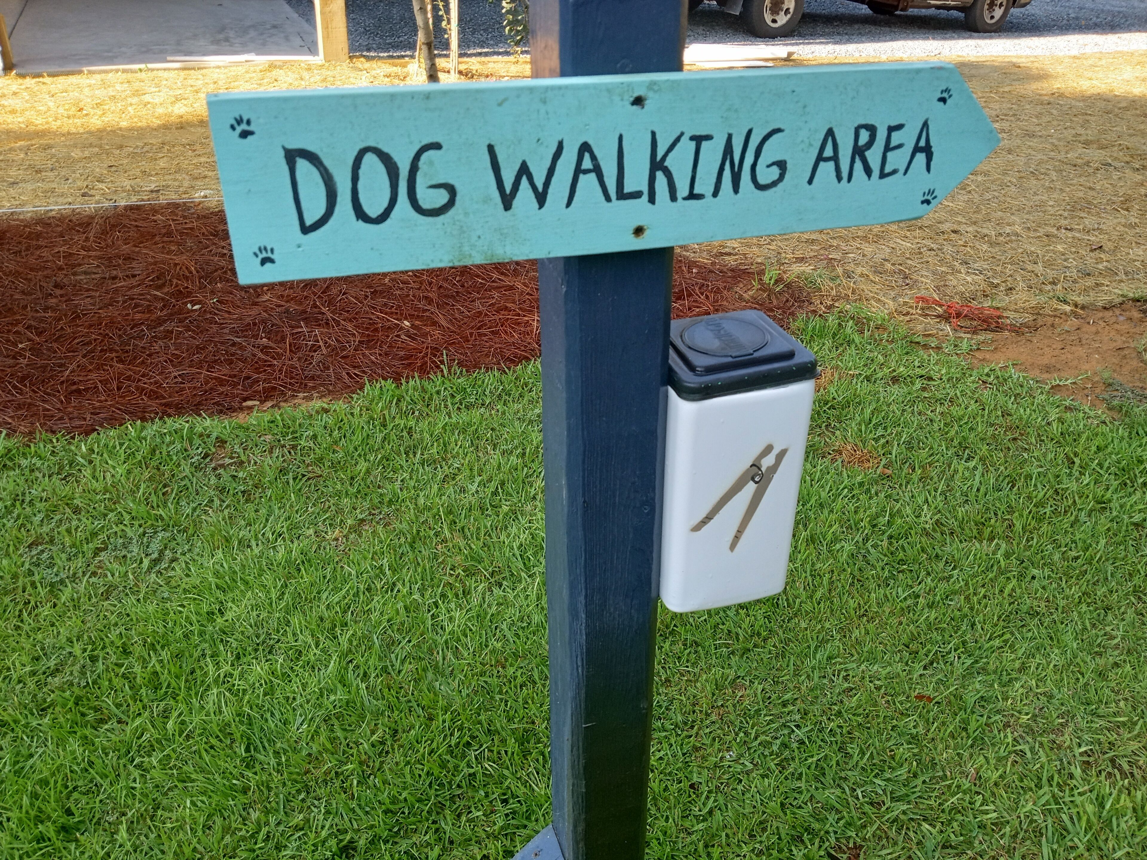 A sign indicating a dog walking area.