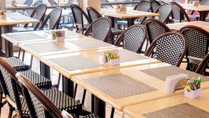 Ein Restaurant mit mehreren Tischen und Stühlen, ansprechend angeordnet in einem großzügigen Raum.