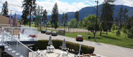 A parking lot with white chairs and umbrellas, a staircase, and a sign warning unauthorized vehicles.