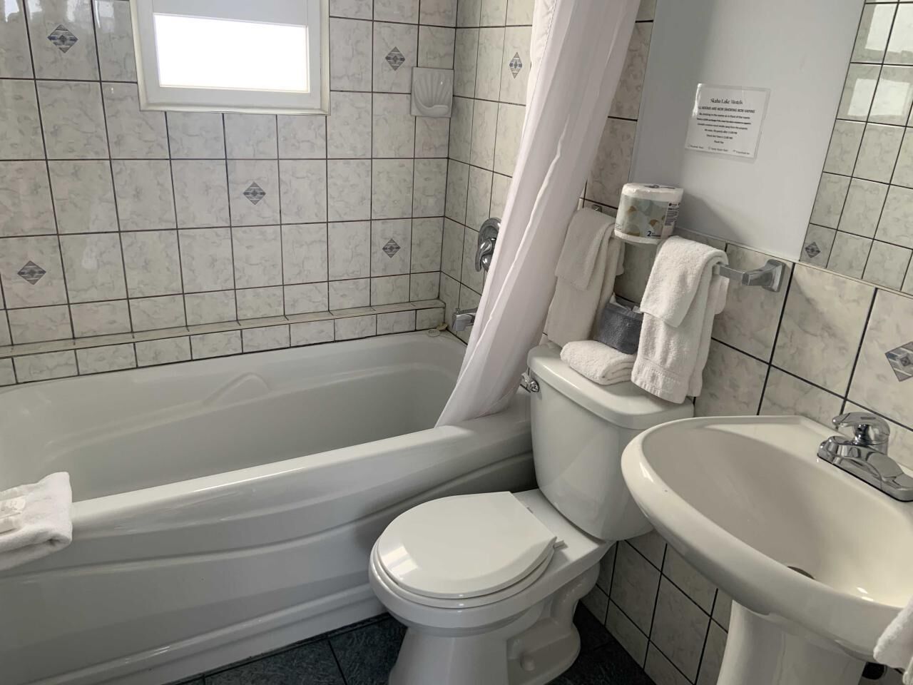 A bathroom with a bathtub, toilet, and sink.