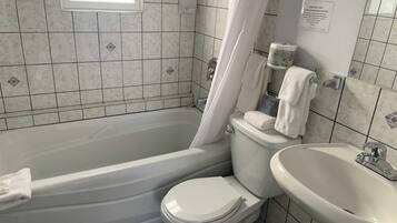 A bathroom with a bathtub, toilet, and sink.