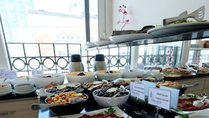 Un bufé con diversas opciones de comida, incluyendo carnes, quesos y aceitunas.
