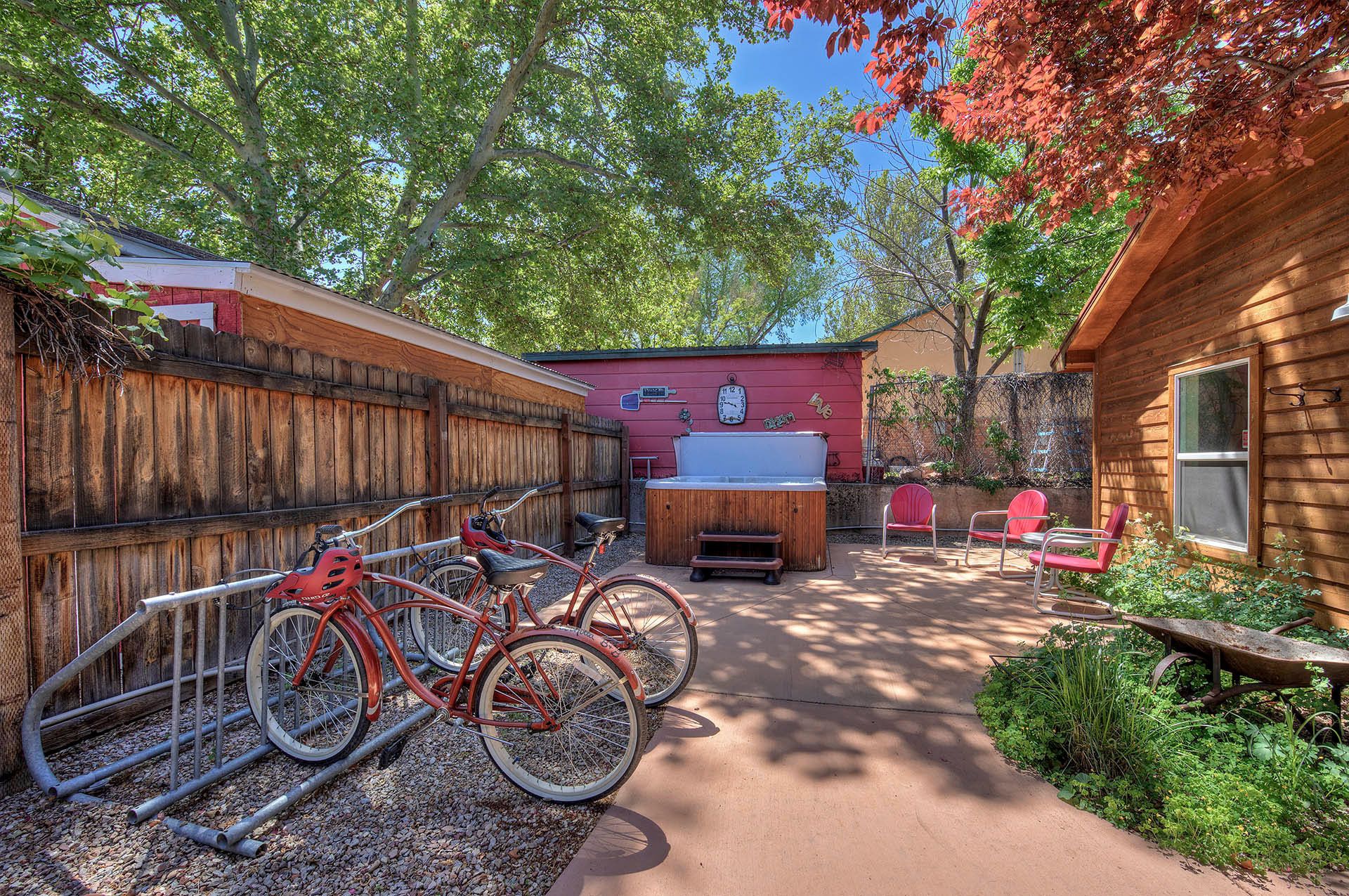 Une cabane en bois avec un jacuzzi, des vélos et un espace salon extérieur.