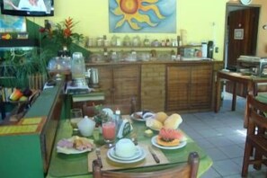 A dining area with a table set for breakfast, including plates, cups, and a blender. - Pousada Solarium (Itacaré)