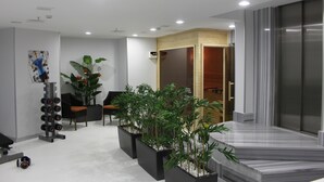 A modern office space with a reception area, seating, a plant arrangement, and a marble reception desk. - Troya Hotel (Istanbul)