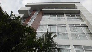 A modern building with a flat roof, multiple windows, and a section of brown wall. - Suites House Juanambu Apartasuites (Cali)