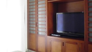 A wooden cabinet with a television on top. - Suites House Juanambu Apartasuites (Cali)