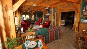 Interior acogedor de una cabaña de madera con comedor, sofá y cocina.
