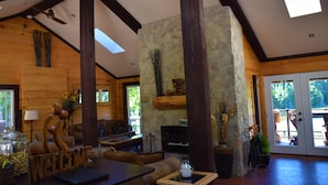 A spacious lobby with a stone fireplace, wooden beams, and a 'WELCOME' sign. - Footprints Resort (Hastings Highlands)