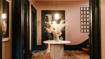 A hallway with a round table, a bench, and a staircase.