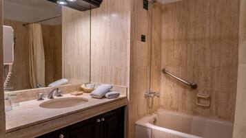 Un baño moderno con lavabo, espejo y bañera.