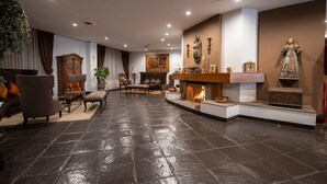 A spacious living room with a fireplace, comfortable seating, and a large statue. - Jose Antonio Cusco Hotel (Cusco)