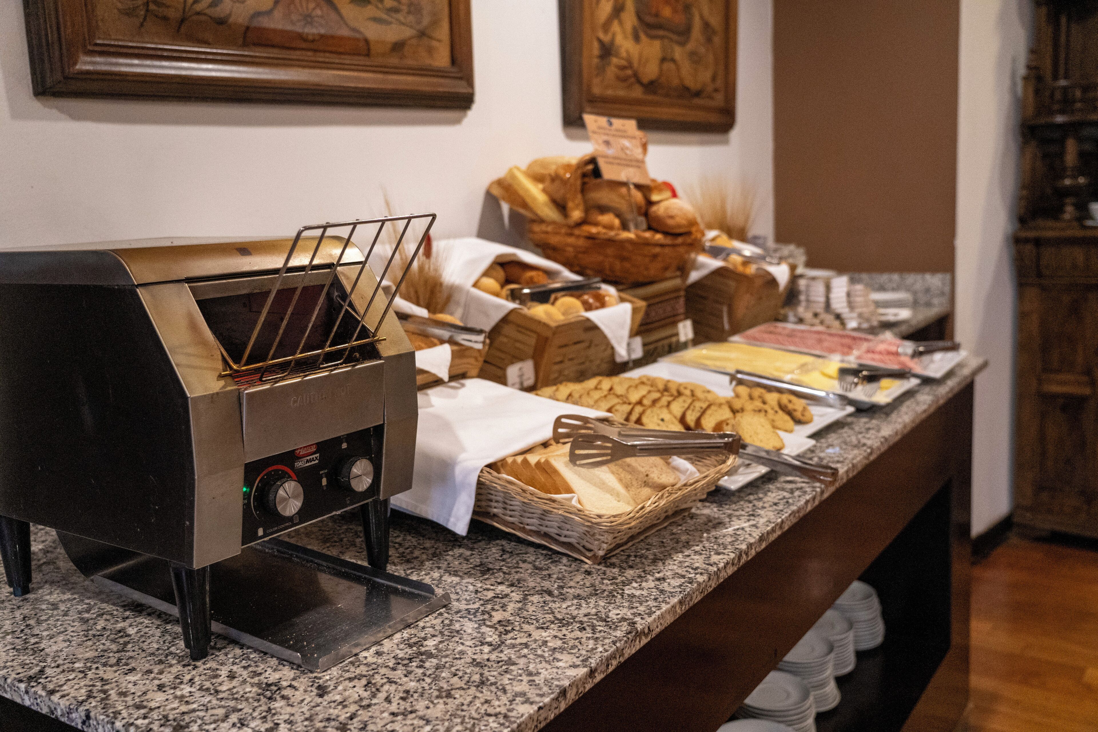 A buffet setup with a self-service grill, various baked goods, and a selection of pastries.