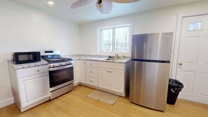 A kitchen with white cabinets, a stainless steel refrigerator, a microwave, and an oven. - The Atlantic, BW Signature Collection (Ocean City)