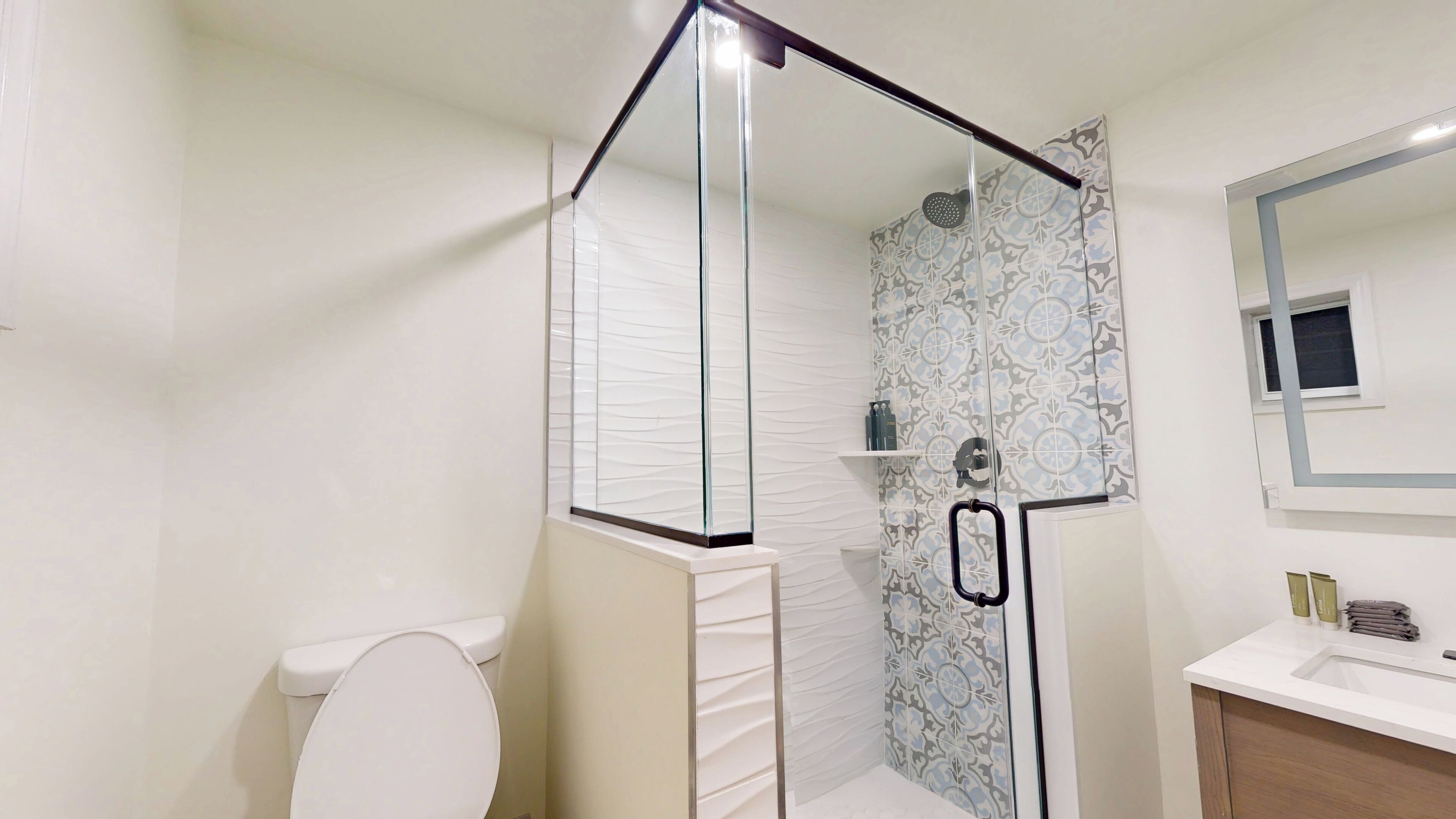 A bathroom with a shower, toilet, and sink.