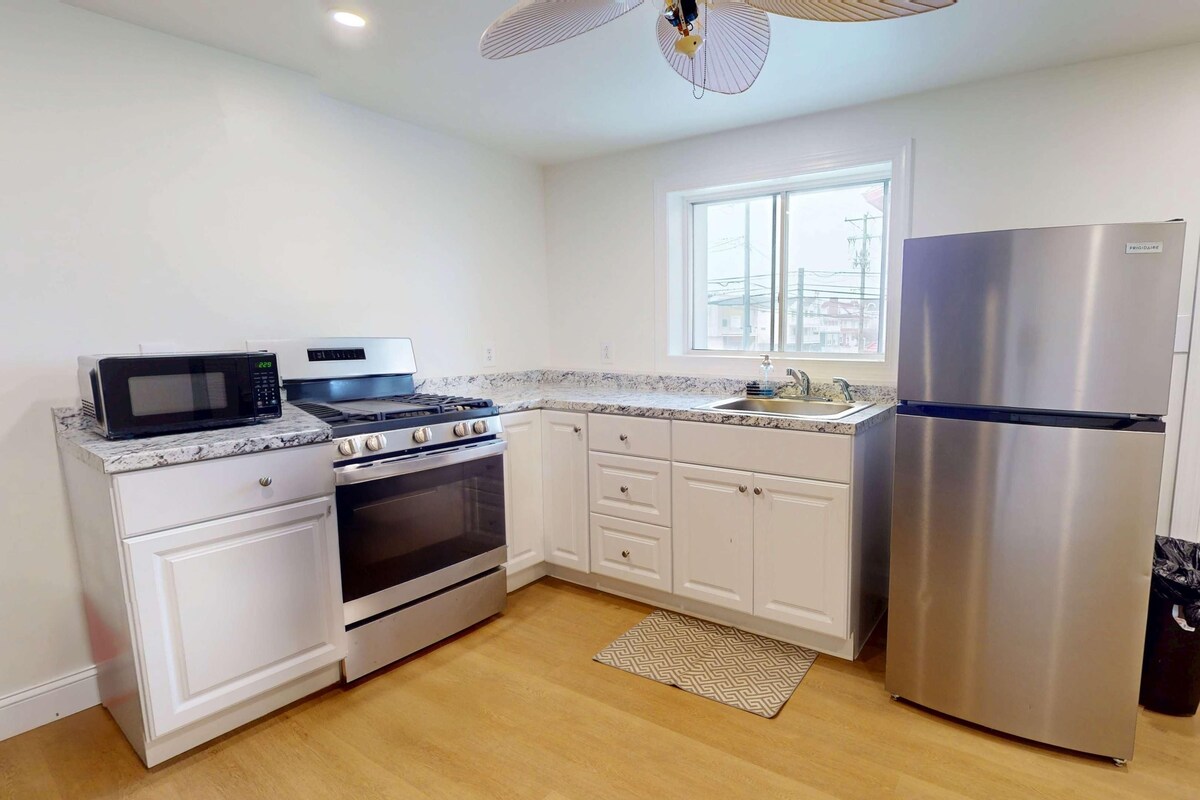 A kitchen with a stove, oven, microwave, sink, and refrigerator.