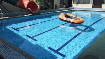 Una piscina al aire libre, sillones reclinables de piscina