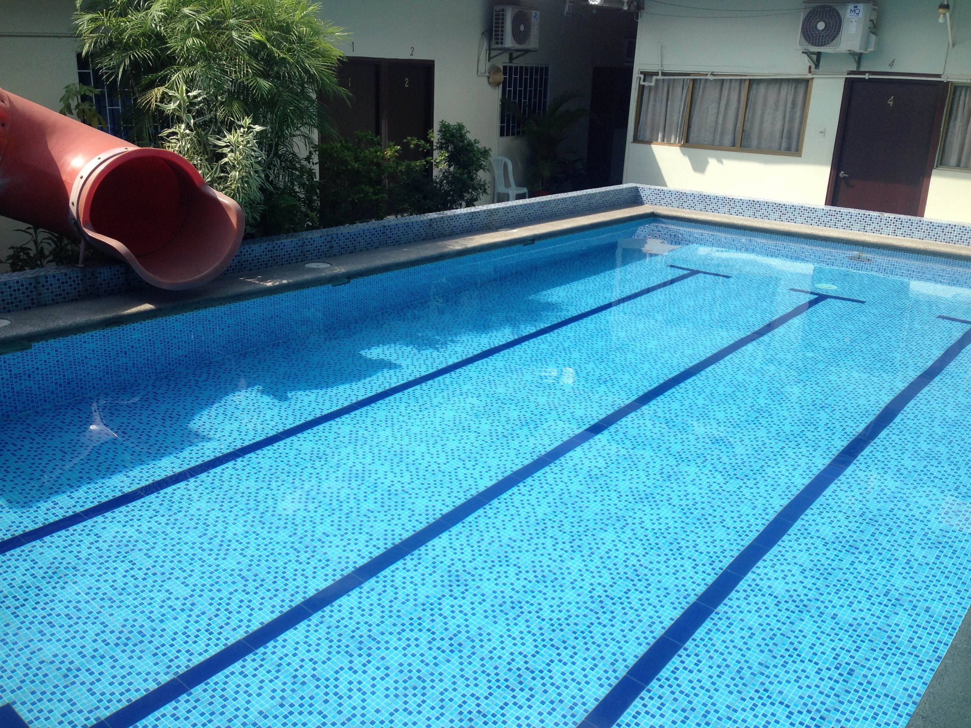 Una piscina al aire libre, sillones reclinables de piscina