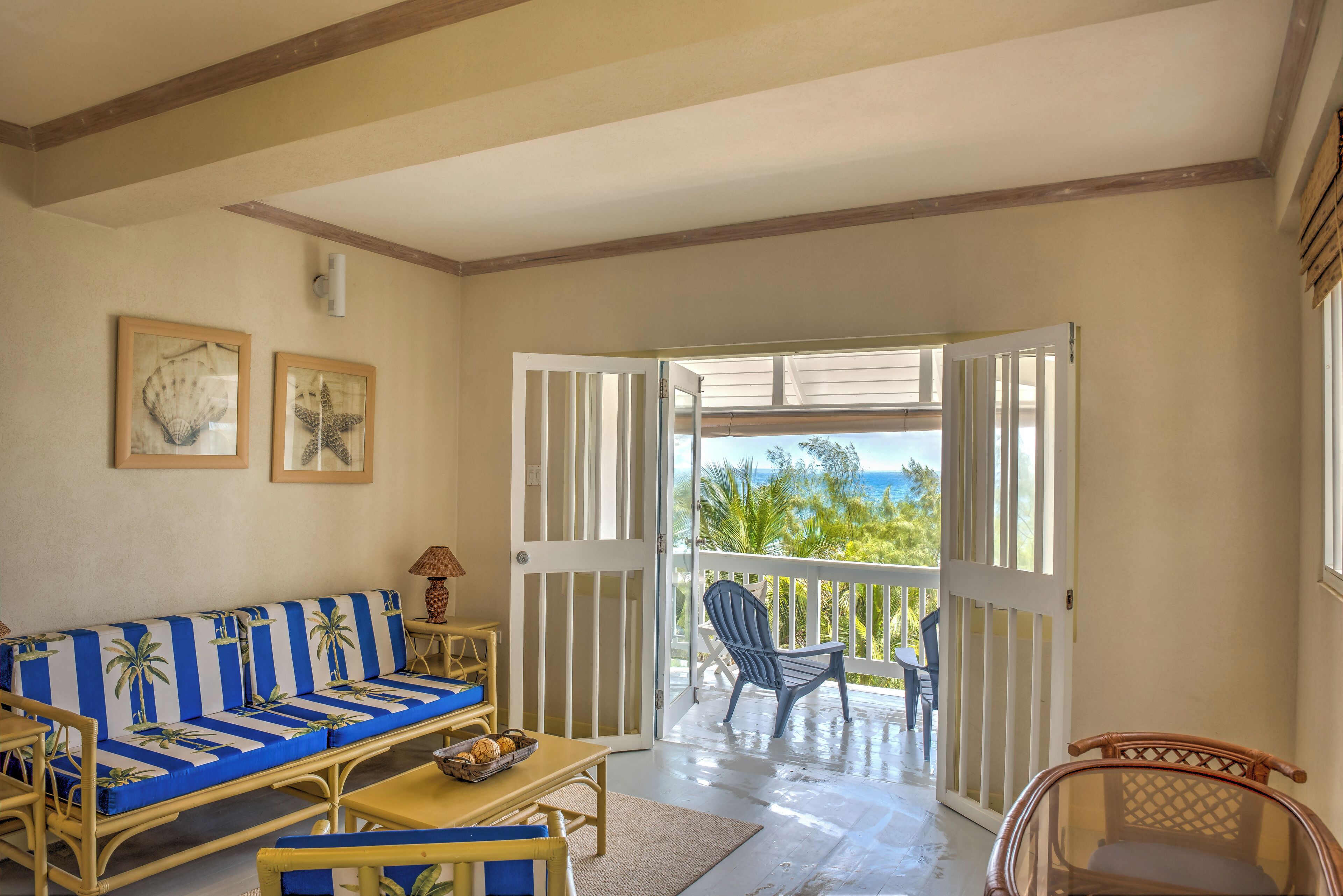 Una habitación con sofá, sillas, una mesa y vistas al exterior.
