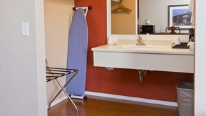 A bathroom with a sink, mirror, and a towel rack. - Flagstone Motel (Port Angeles)
