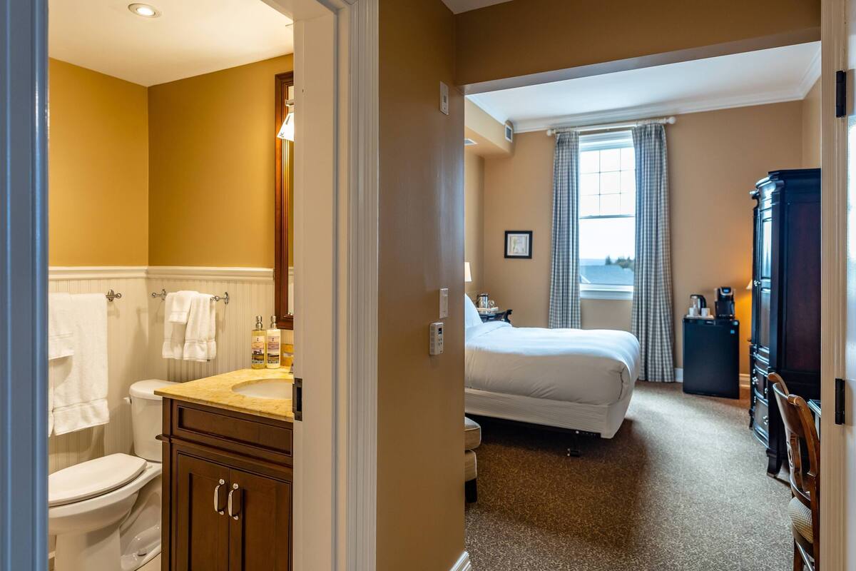 Une chambre d’hôtel avec une salle de bain, un lit et un bureau.