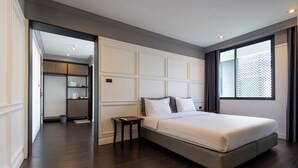 A modern bedroom with a large bed, a nightstand, and a walk-in closet. - Penpark Place (Bangkok)