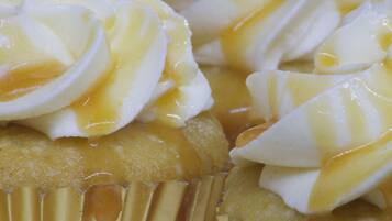 Primer plano de un postre con crema batida y hilo de caramelo.
