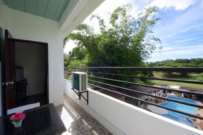 A balcony with a view of a swimming pool and lush greenery. - Ala Amid Bed & Breakfast (Puerto Princesa)