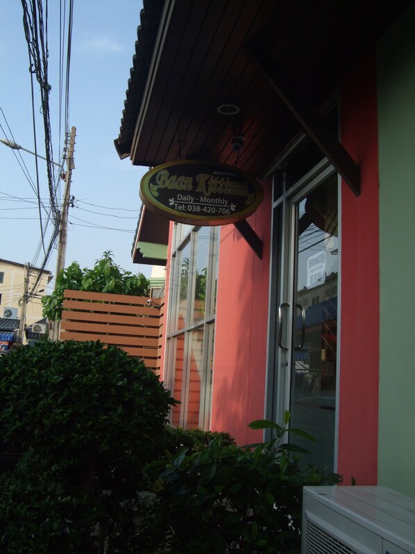 A building with a sign that reads "Baan Kittima Daily - Monthly Tel: 038-420-706".